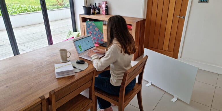 Donna che lavora da casa e si gode il calore della stufa portatile Herschel Select