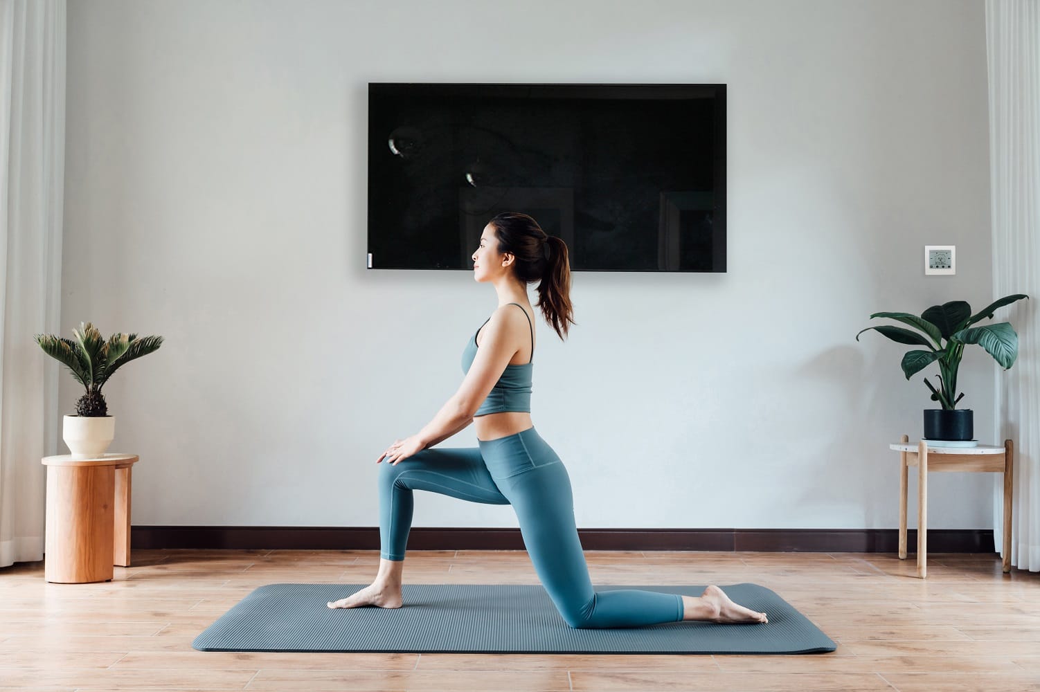 Un pannello di vetro nero riscalda una donna che si allena a casa